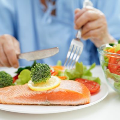Hospital patient cutting into food on tray