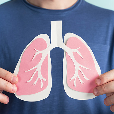 Someone holding a paper cutout of lungs