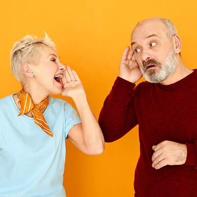 Person shouting to another person cupping their ear